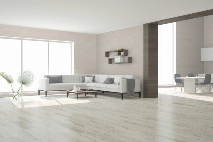 Modern living room with a white sofa, coffee table, porcelain wood look tile floor and decorative elements.