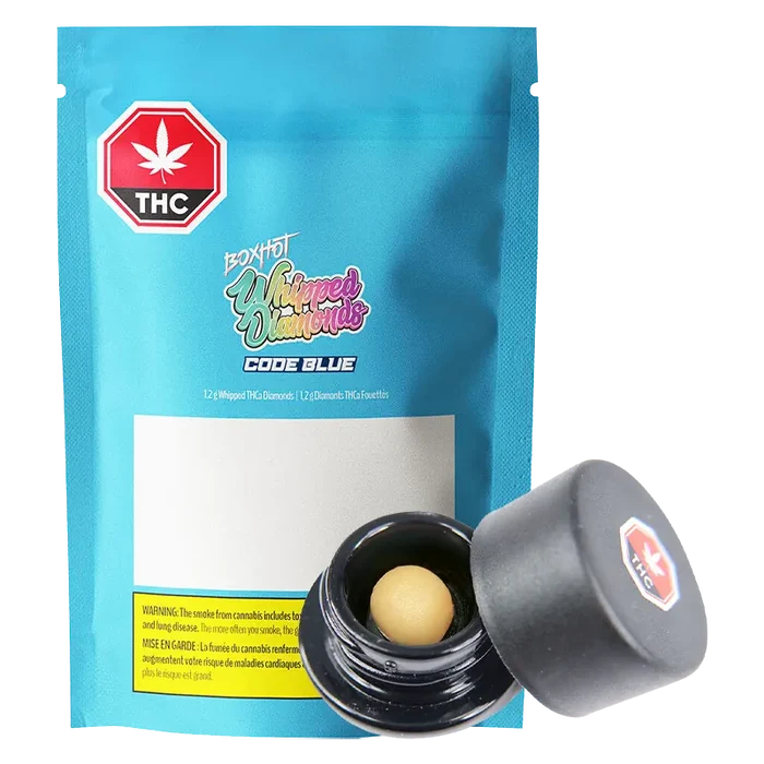 Front-facing shot of a blue pouch and open jar showing a beige ball concentrate, labeled Code Blue Whipped Diamonds.