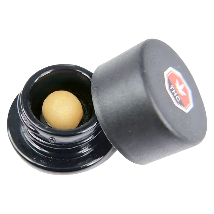 Close angled view of an open black jar revealing a smooth tan sphere inside, labeled as Code Blue Whipped Diamonds.